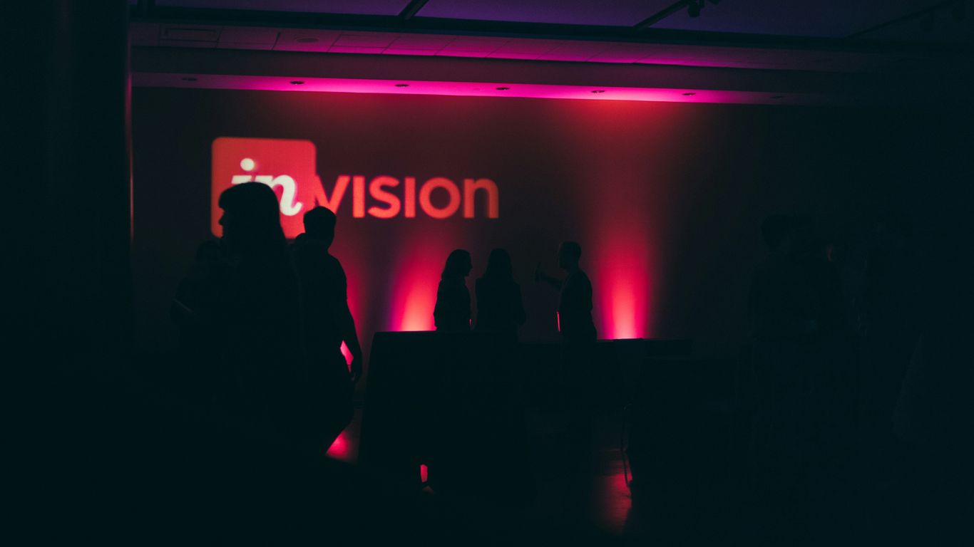 a group of people standing in front of a vision sign
