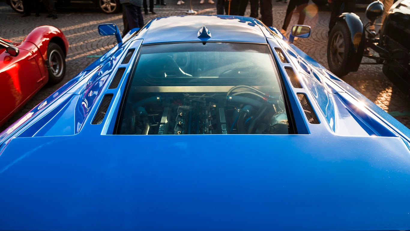 A blue sports car parked next to a red sports car