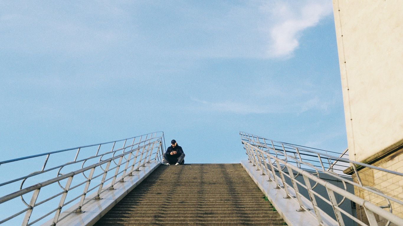 a man sitting on top of a set of stairs
