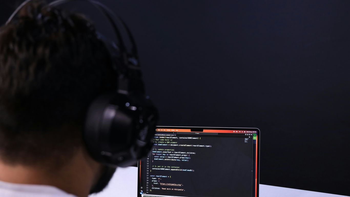 a man wearing headphones and using a laptop