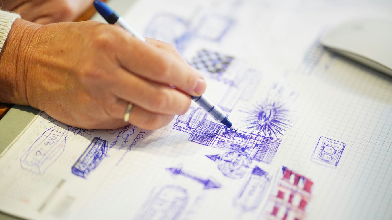 selective focus photography of person sketching