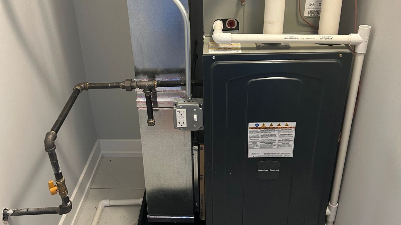 Furnace and air conditioning unit with pipes and electrical outlet.