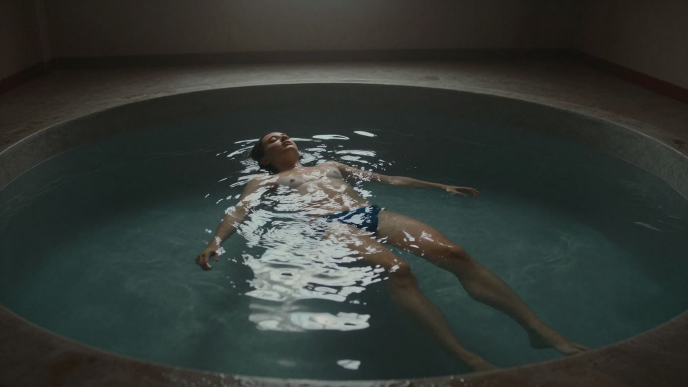 Personne flottant paisiblement dans un réservoir d'eau sombre.