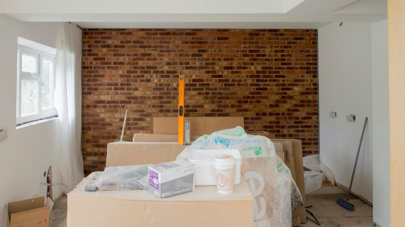 A room with a brick wall and boxes on the floor