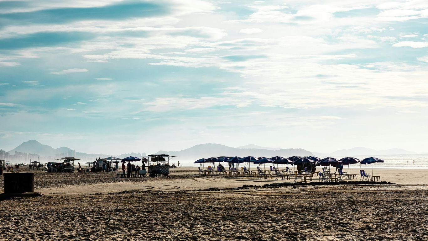 Beach with umbrellas and mountains in distance