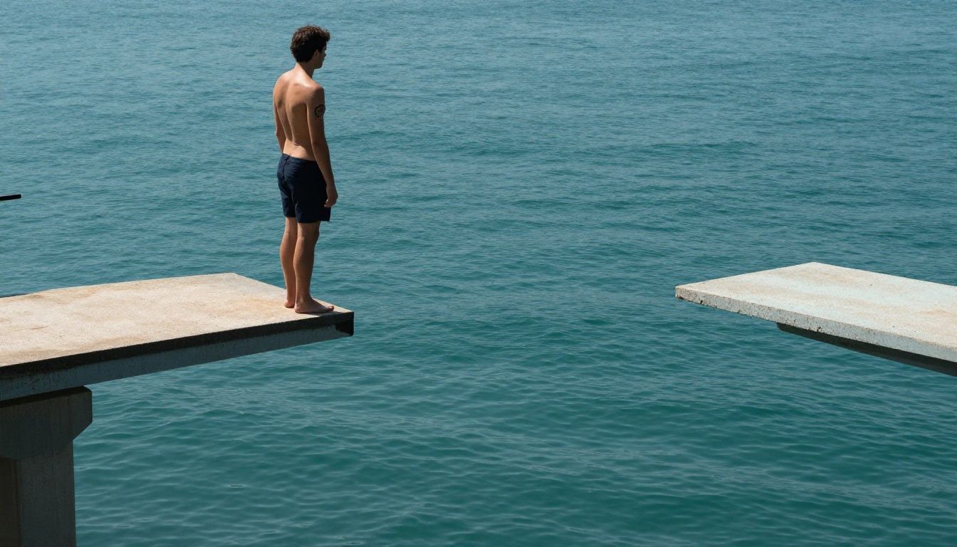 A person standing at the edge of a diving board, looking at the water below, symbolizing the moment of decision before taking a leap of action.