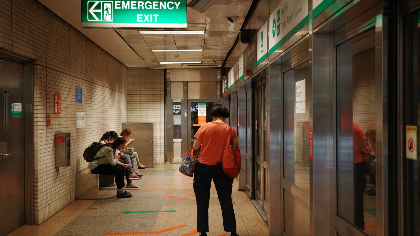 A group of people sitting on a bench in a hallway