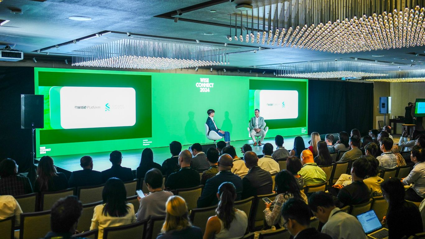 A panel discussion is taking place in front of an audience.