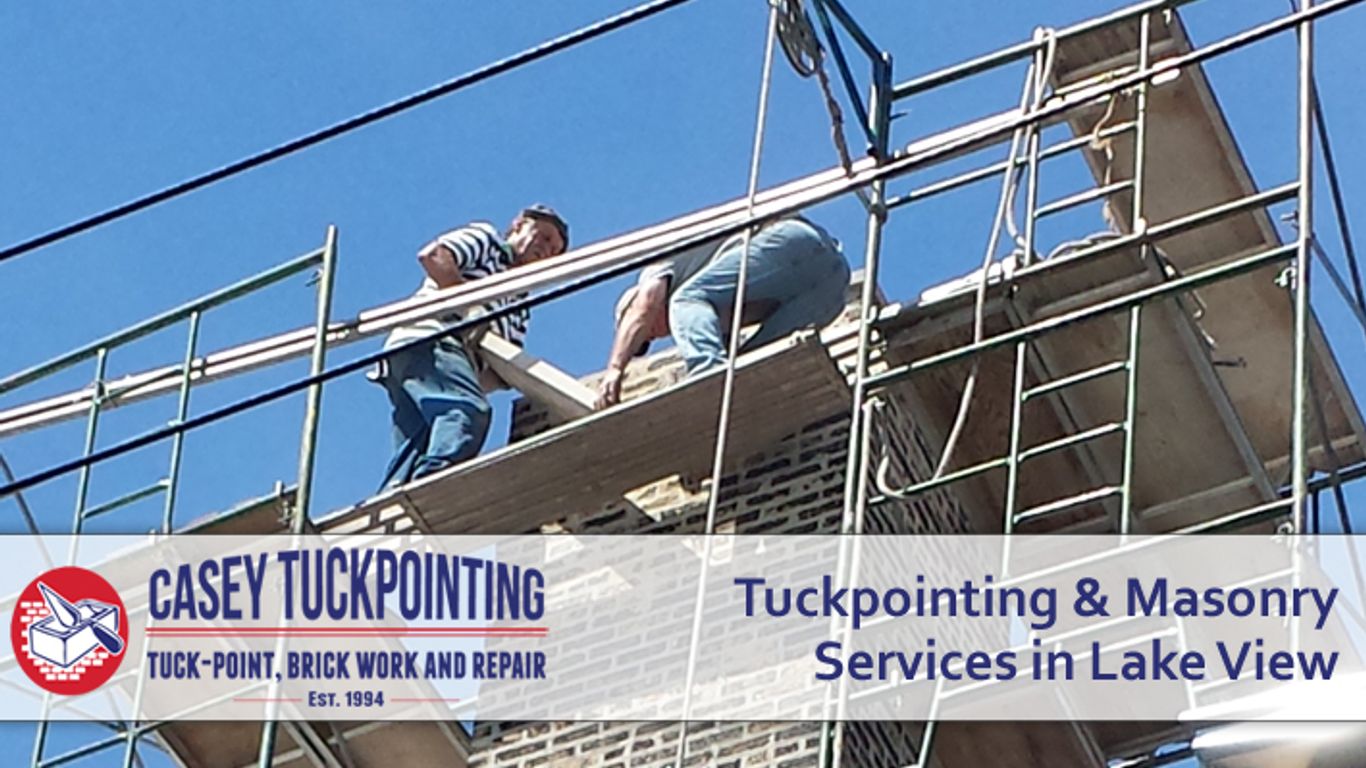 Workers on scaffolding performing tuckpointing and masonry services.