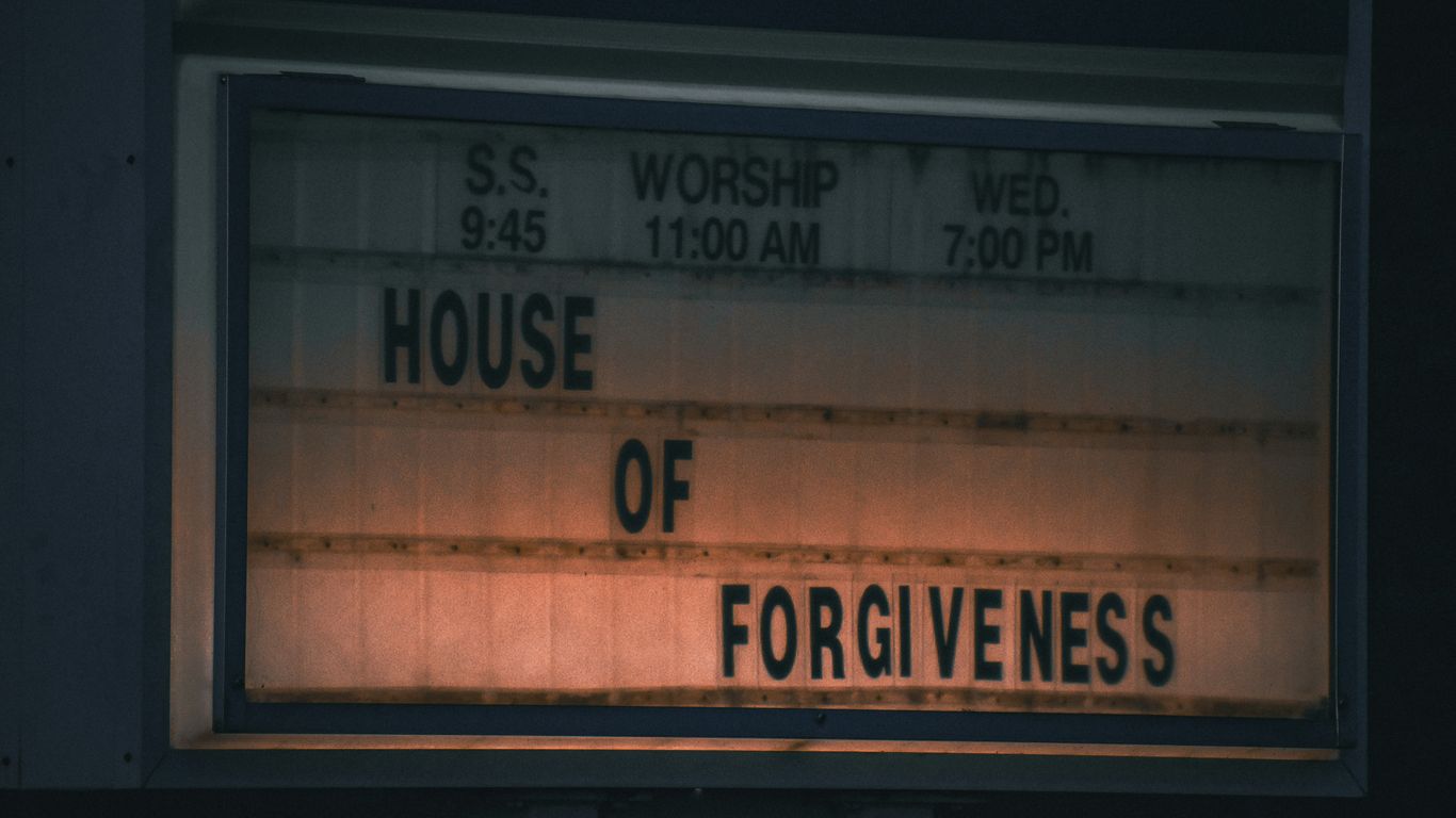 a sign that says house of forgivenes in front of a church