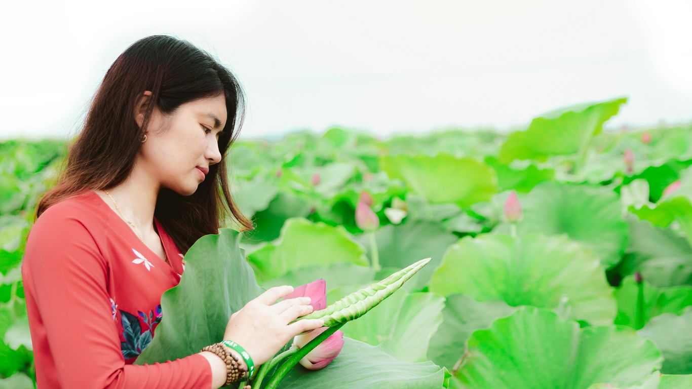 a woman looking at a leaf