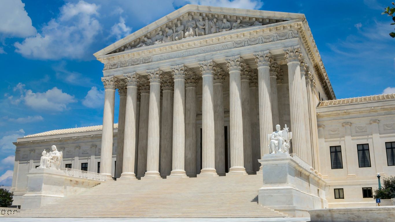 a large white building with columns with United States Supreme Court Building in the background