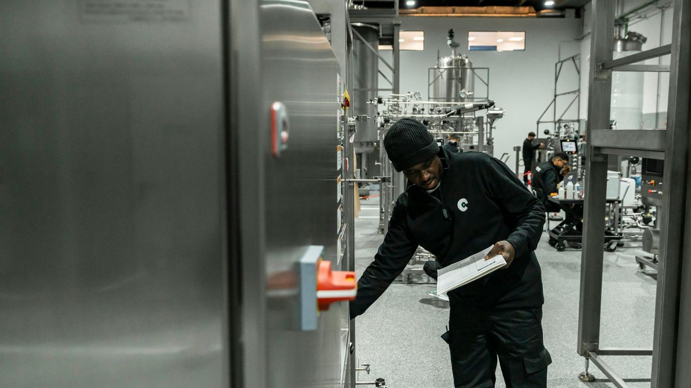 A man inspects equipment in a modern factory.