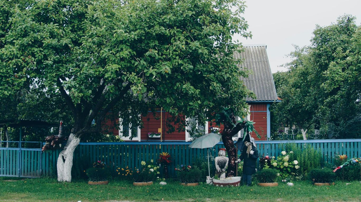 Red house with blue fence and garden