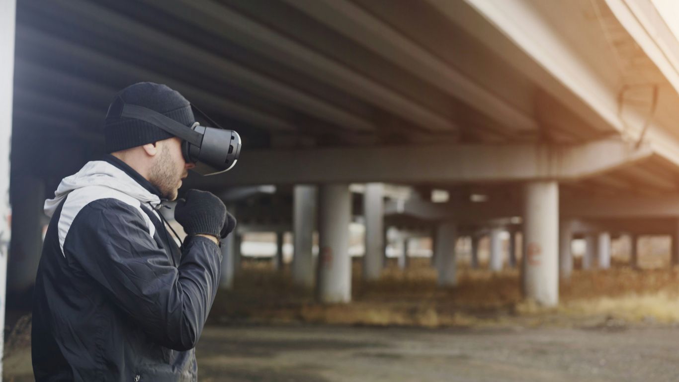 Man wearing vr headset under a bridge
