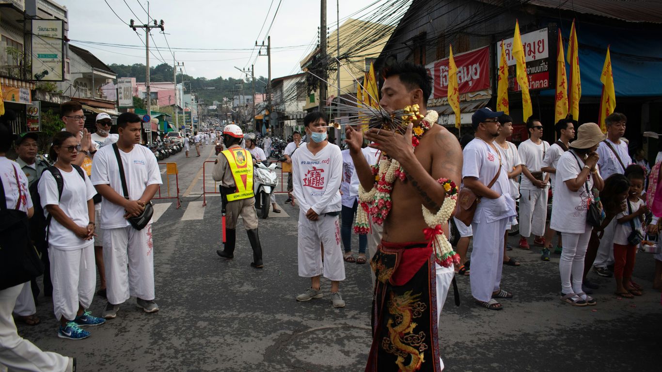 woman in red and brown floral dress standing on gray concrete floor during daytime