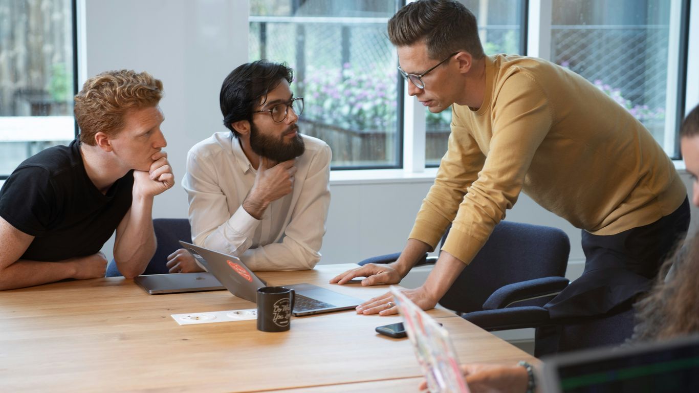 a group of people sitting around a wooden table