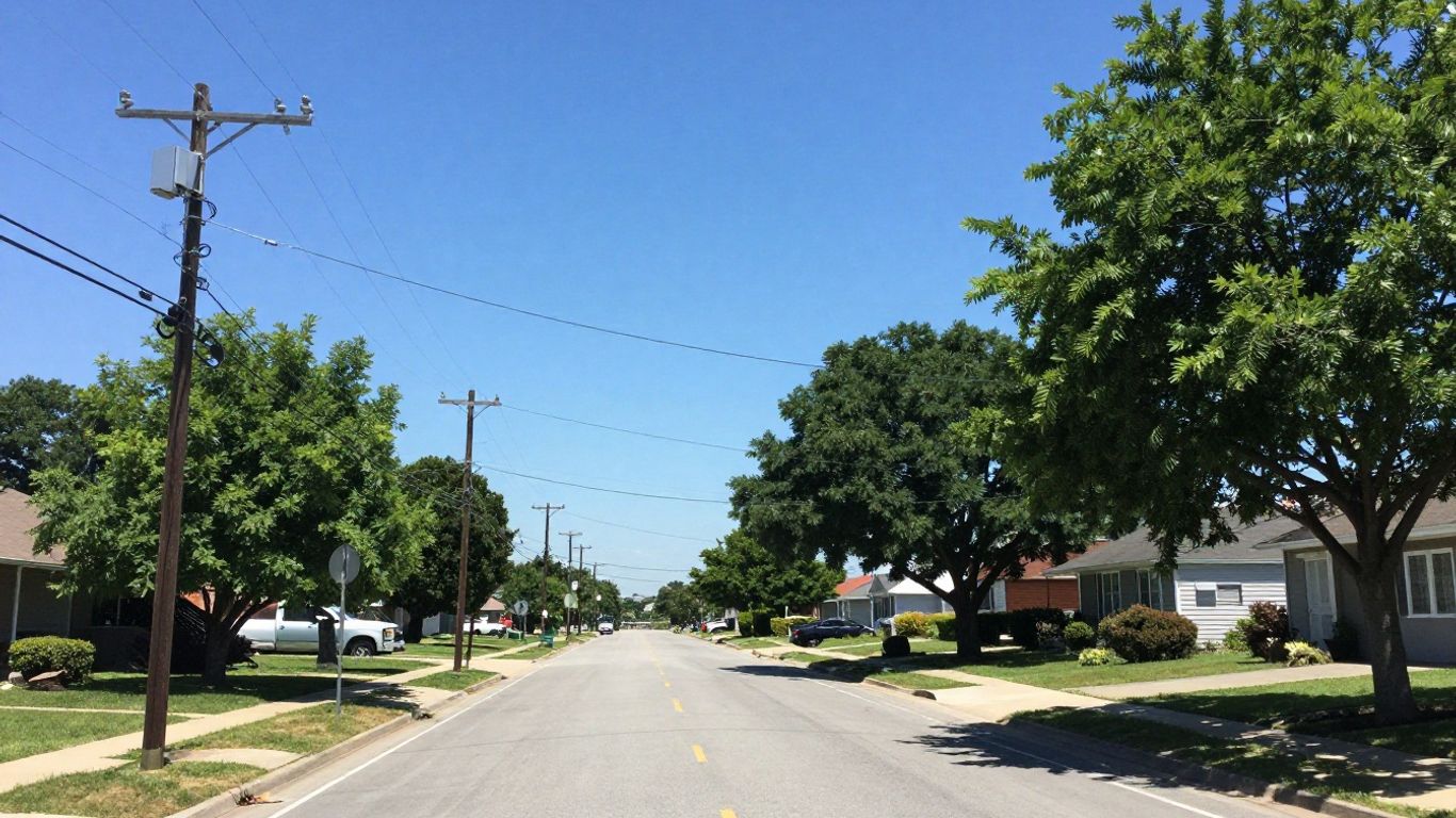 County utility poles and wires against a blue sky.