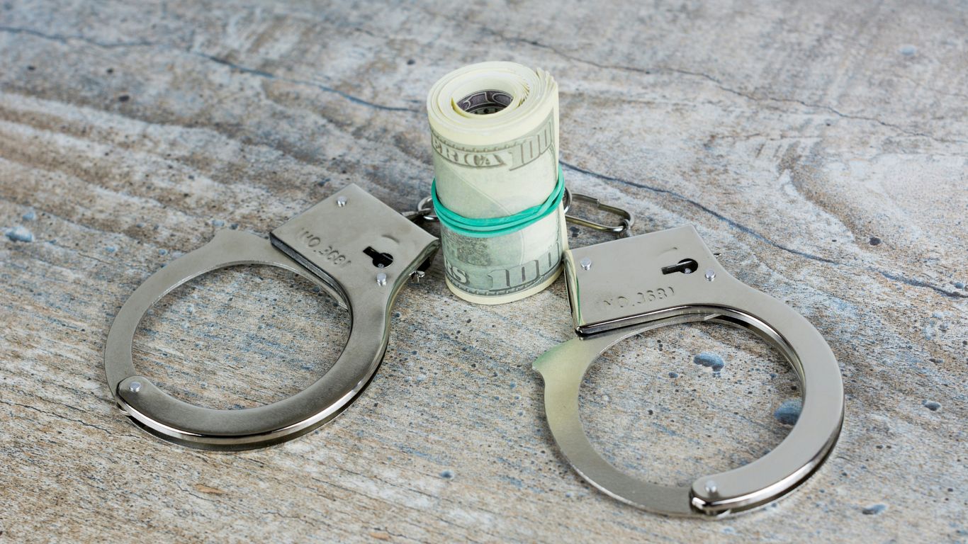 a pair of scissors and a roll of money on a table