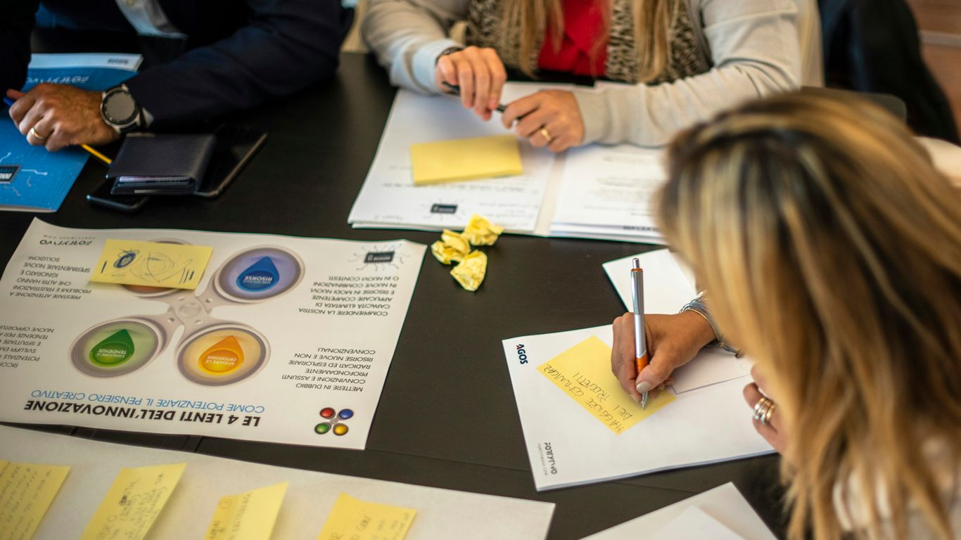 a group of people sitting around a table with papers
