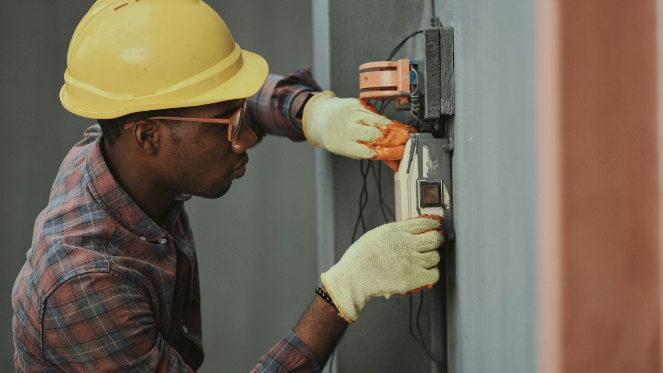 Eletrotécnicos realizando inspeção em painéis industriais