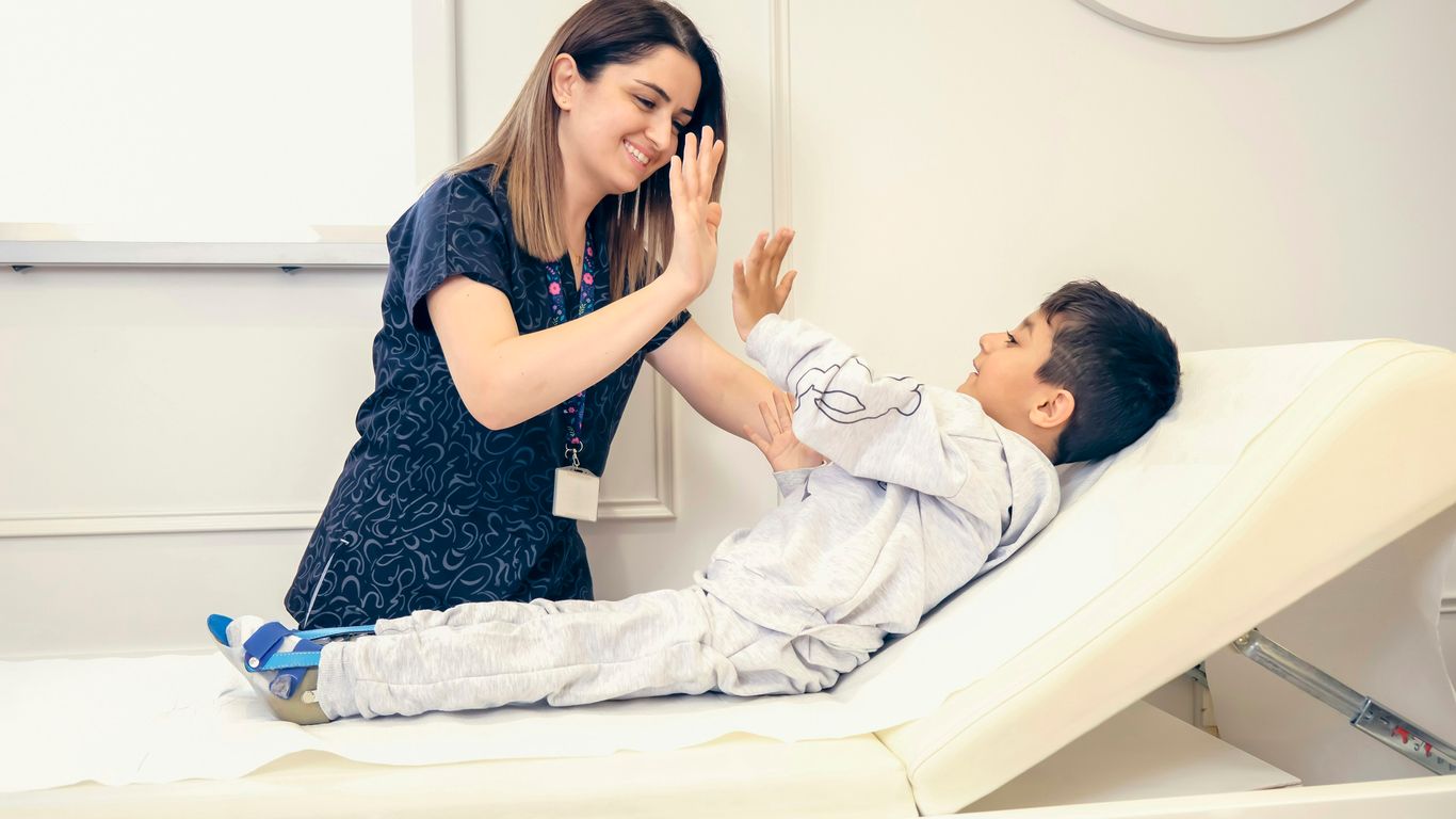 a woman is giving a boy a high five
