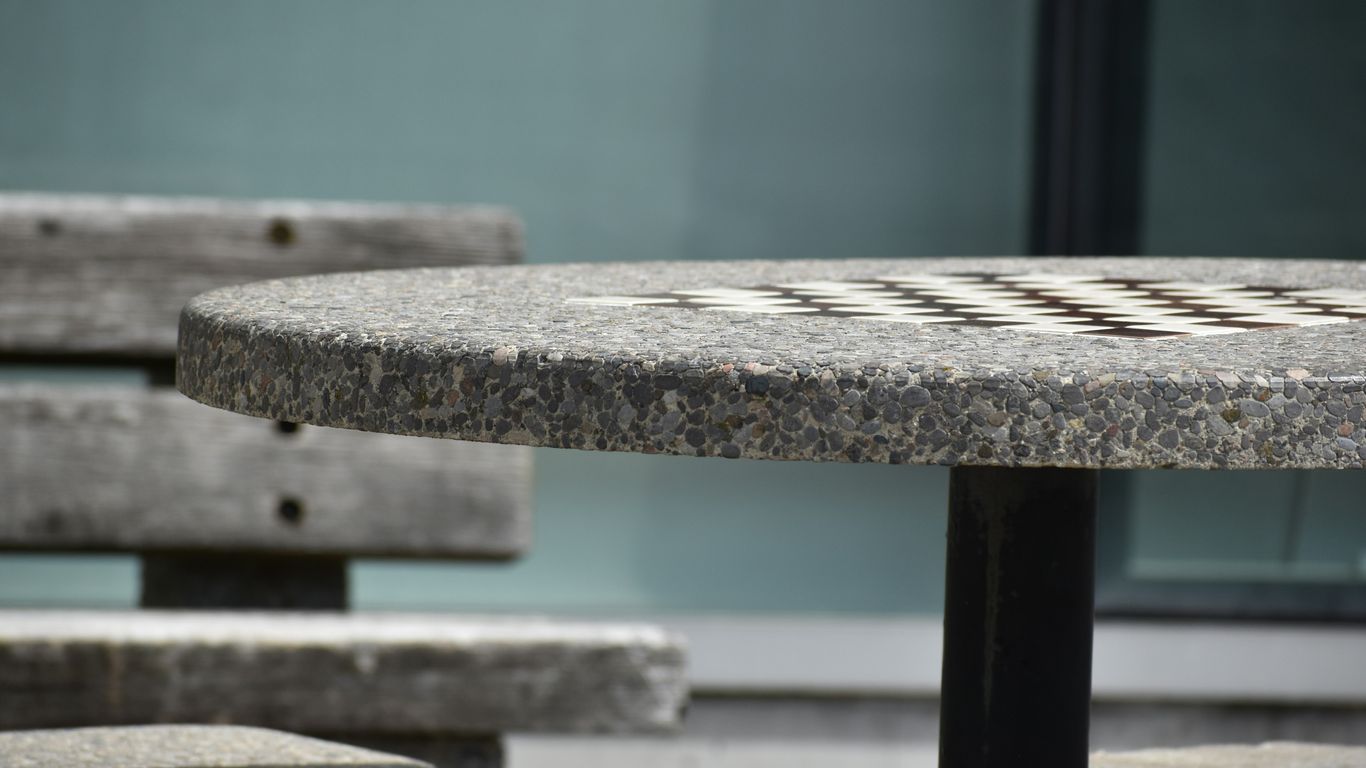 Hands cleaning a pale stone tabletop