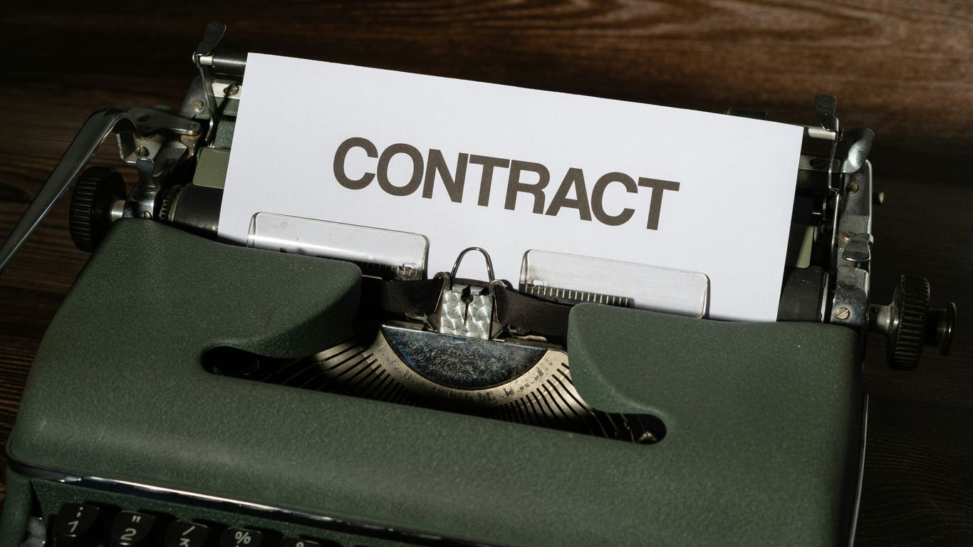a close up of a typewriter with a sign that reads contact