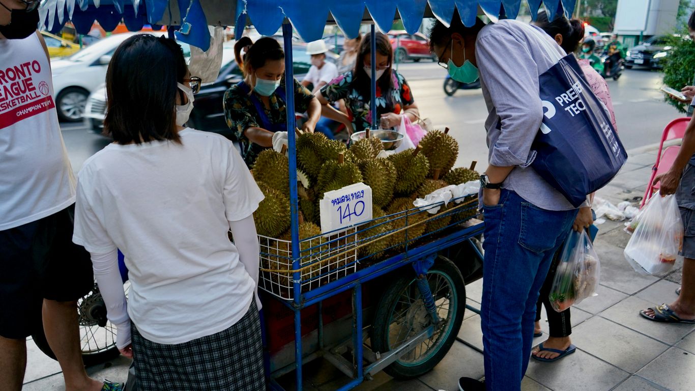 people standing around a fruit stand
