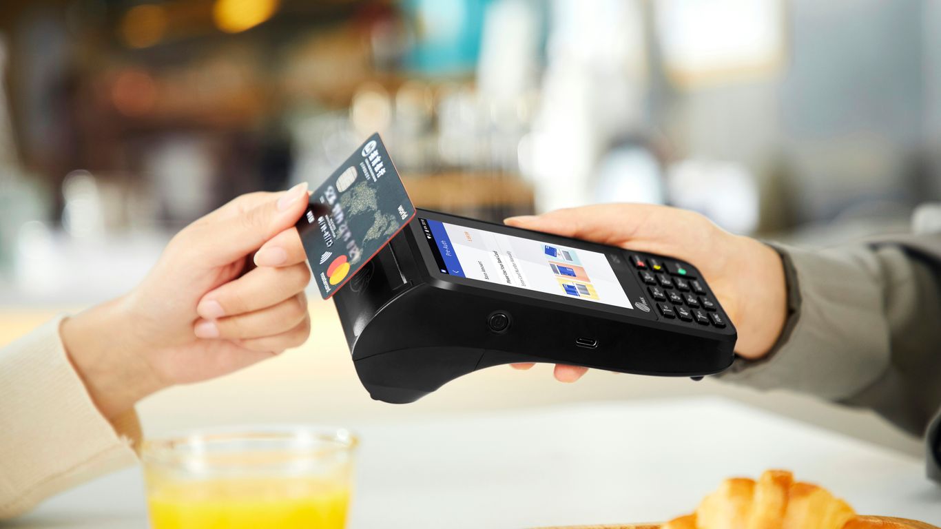 person holding black smartphone near clear drinking glass