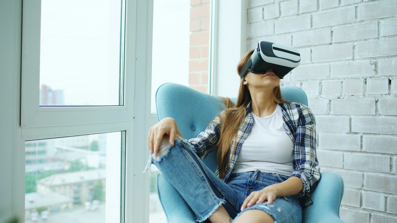 Woman wearing vr headset sitting in armchair