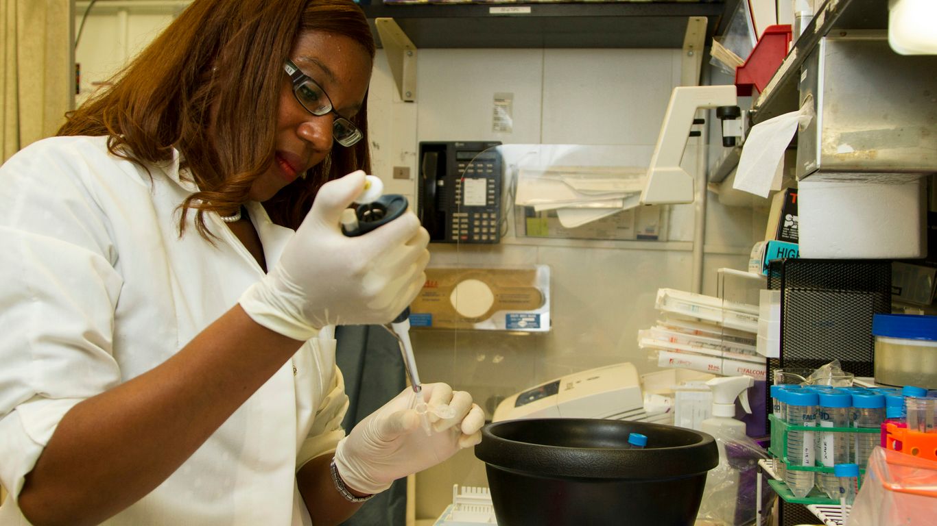woman in white shirt holding black ceramic mug