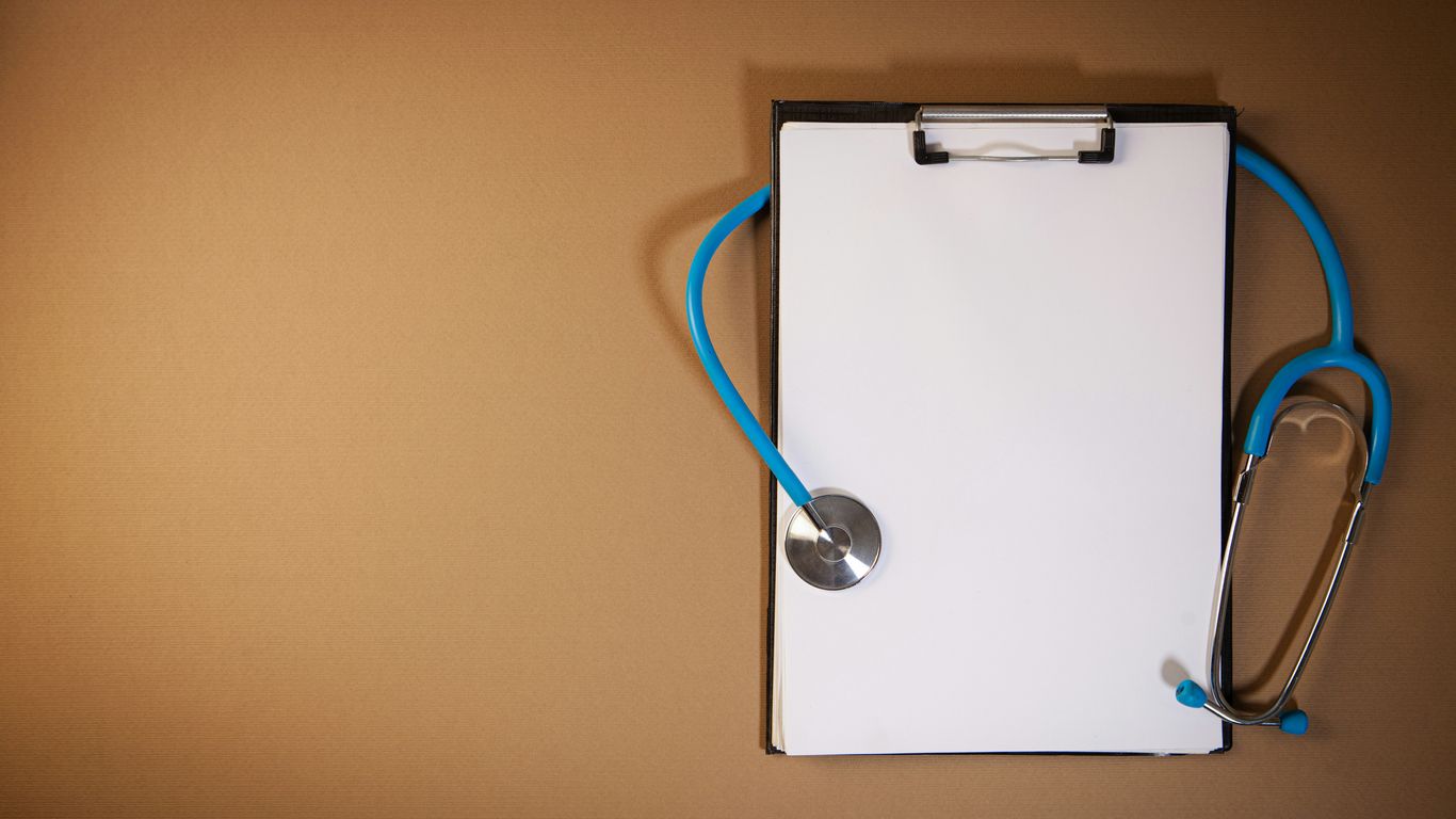Clipboard with stethoscope on a brown background
