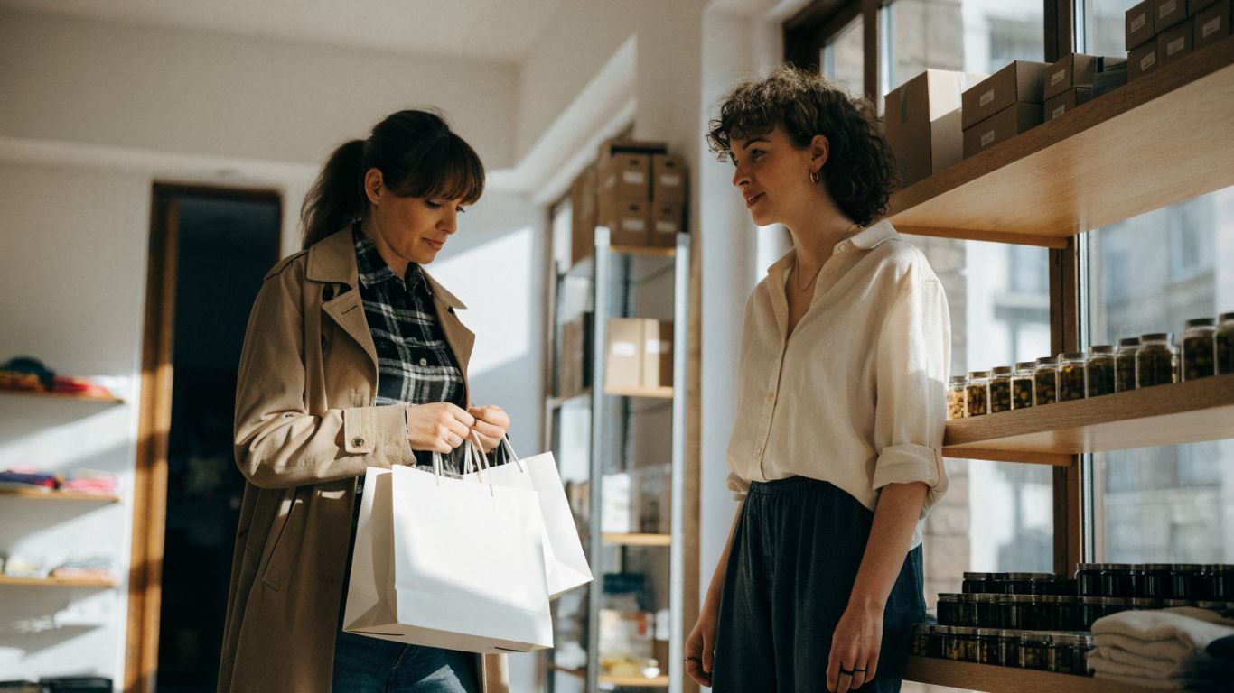 Retail employee welcoming a customer in a bright store