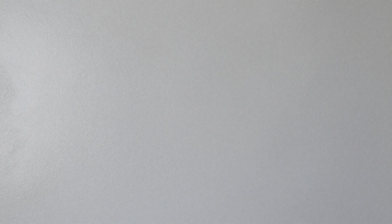 A close-up of a smooth, light grey polished Venetian plaster wall, showing its subtle texture and soft sheen