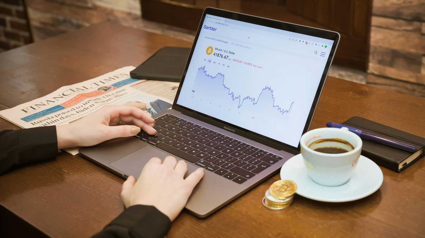 a person using a laptop on a table with a cup of coffee
