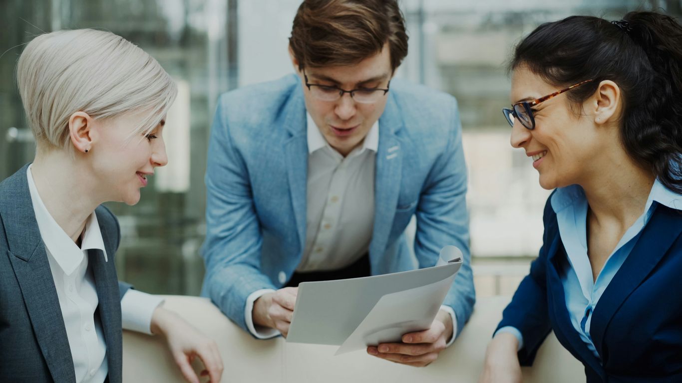 Three professionals discussing a document together