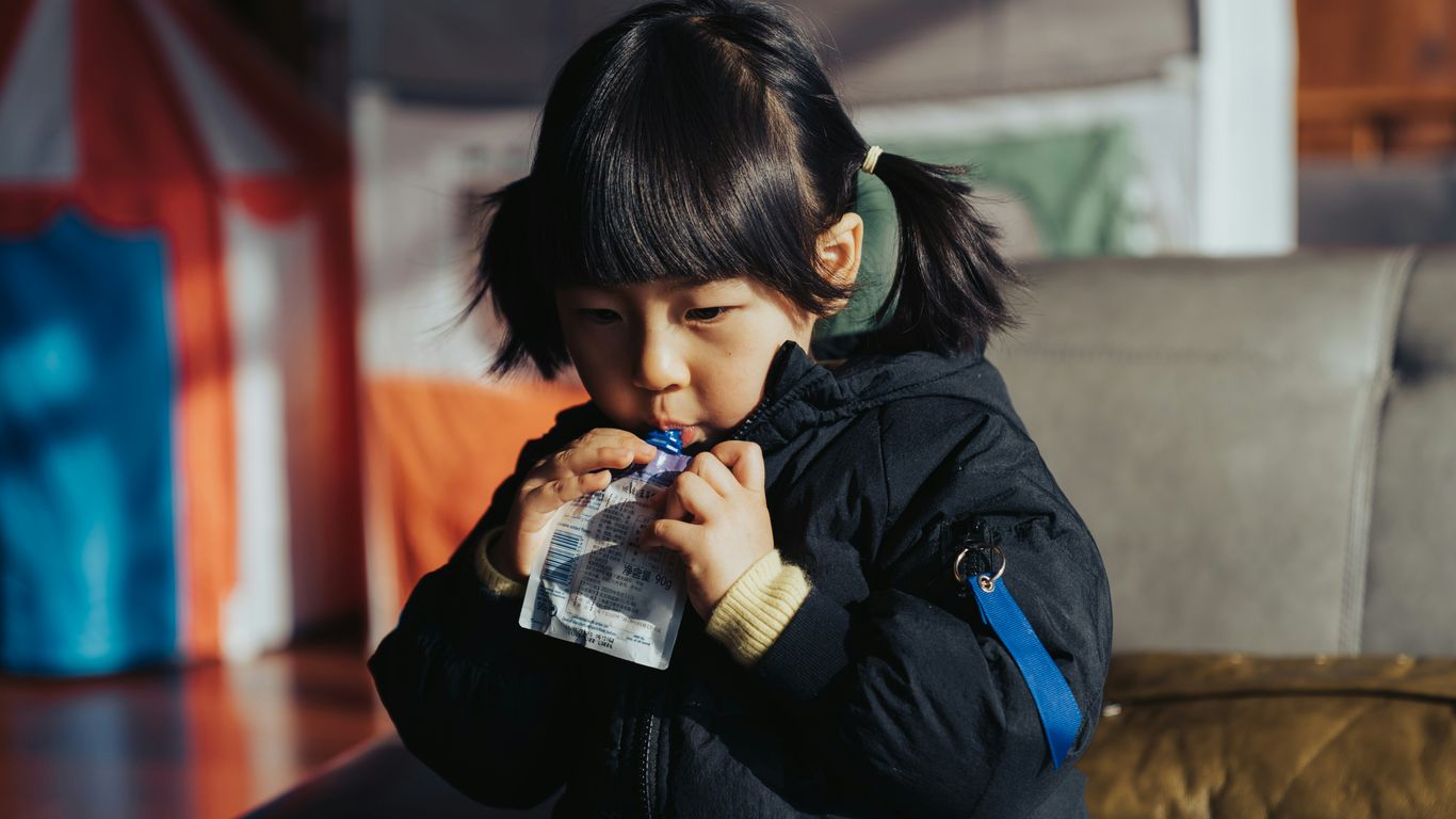 a little girl drinking from a plastic bottle