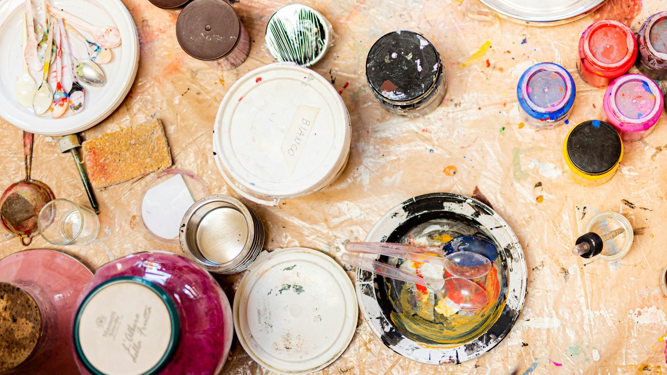 Studio workspace showing various paint mixing pots