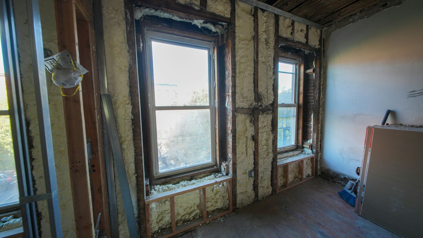 Room under construction with exposed insulation and windows