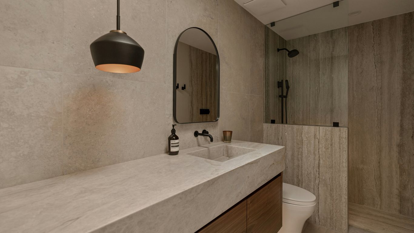 Layered natural stone bathroom with soft daylight