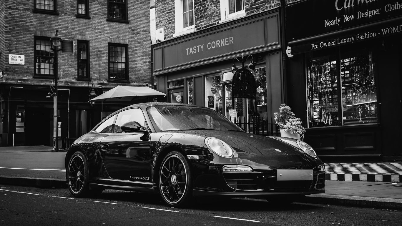 Black porsche parked on a city street.