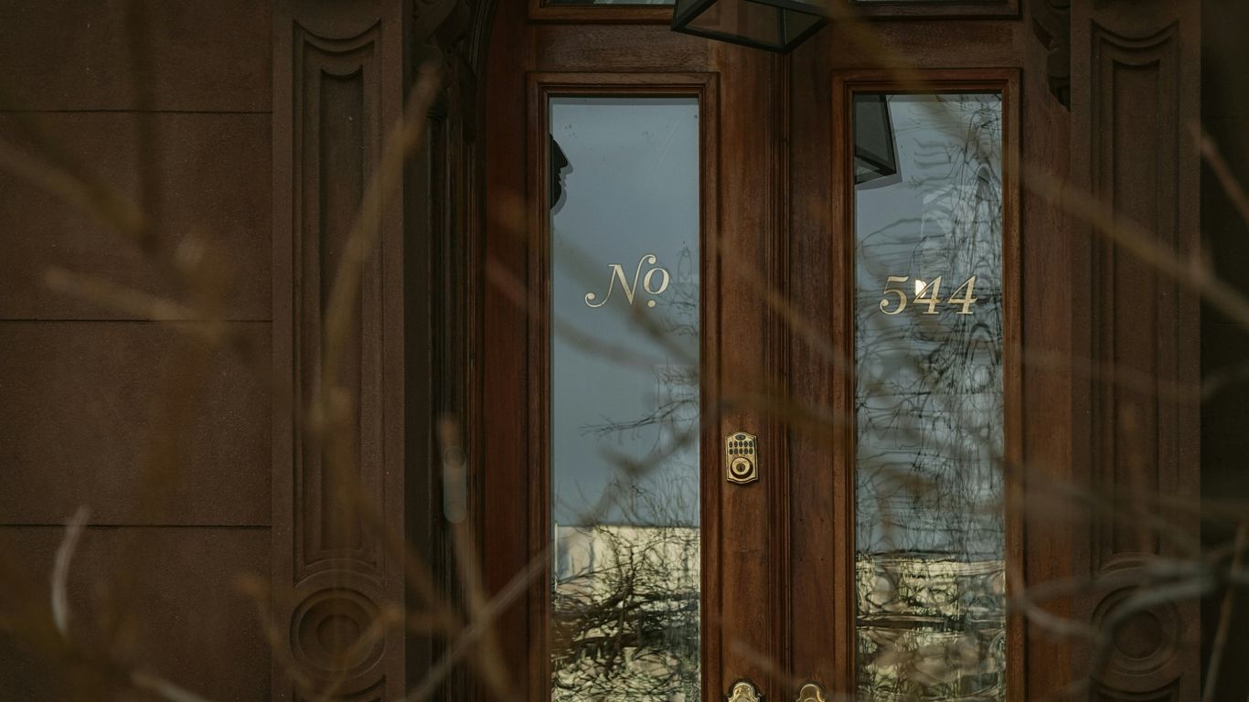 Wooden doors with glass panels and house numbers.