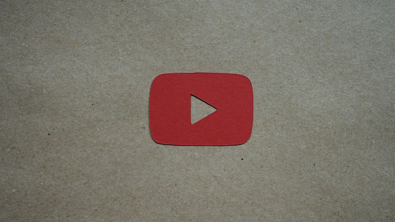 a red play button sitting on top of a piece of paper