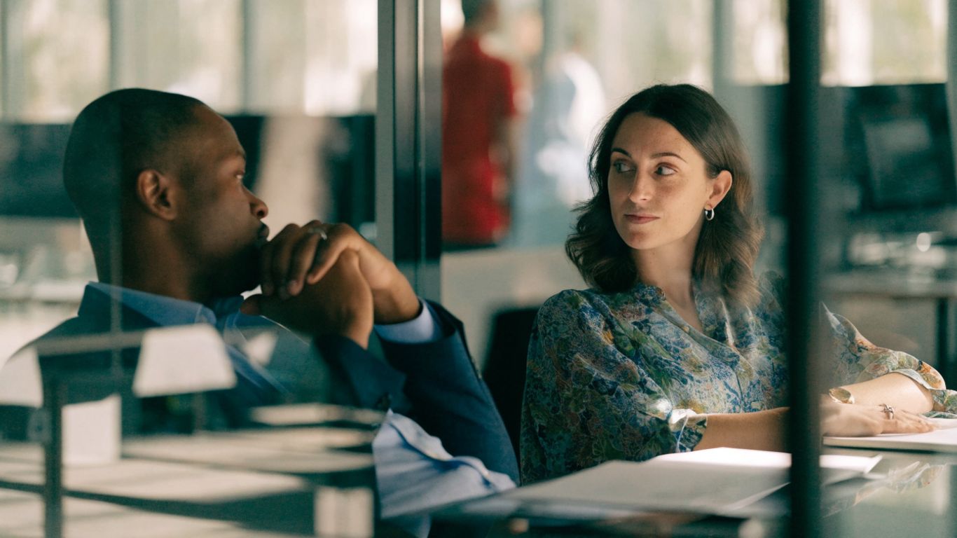 Manager and assignee reviewing work together in an office