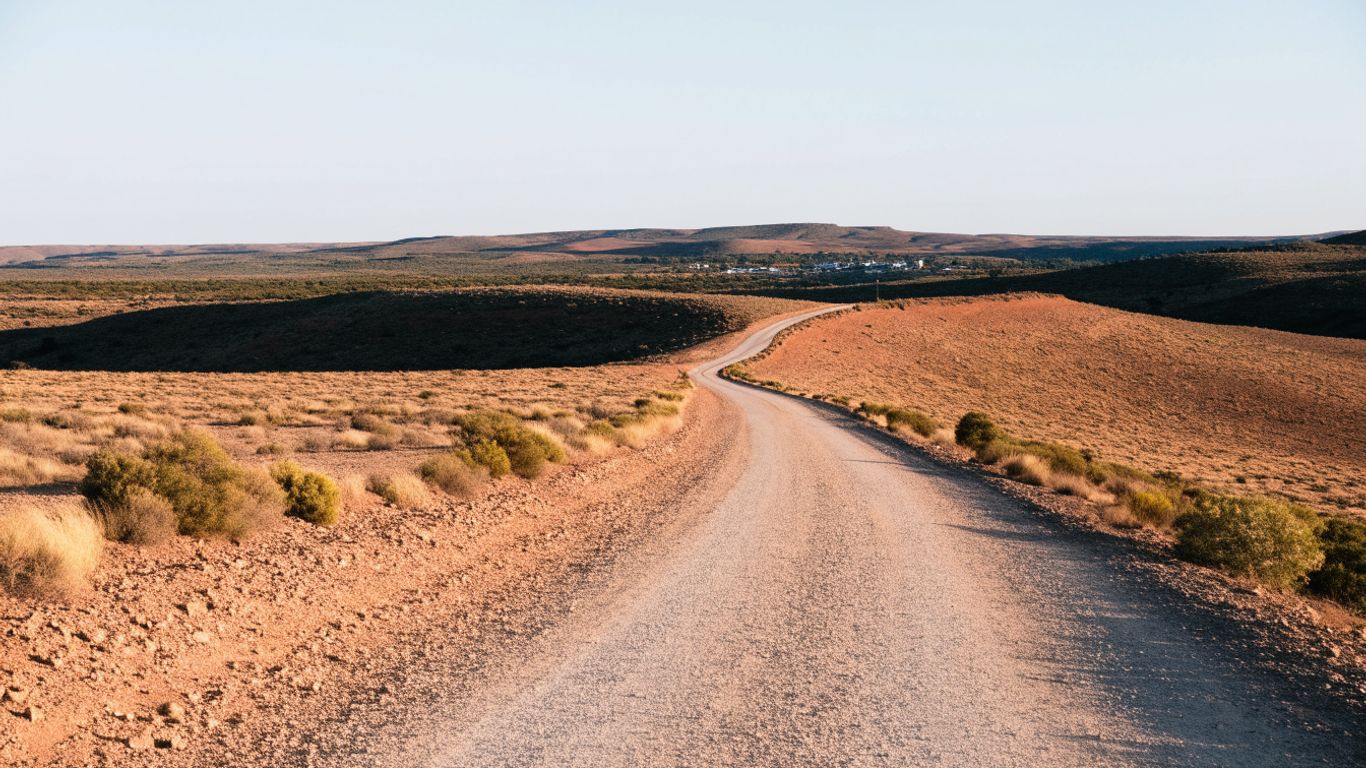 Remote Australian road crossing open rugged country