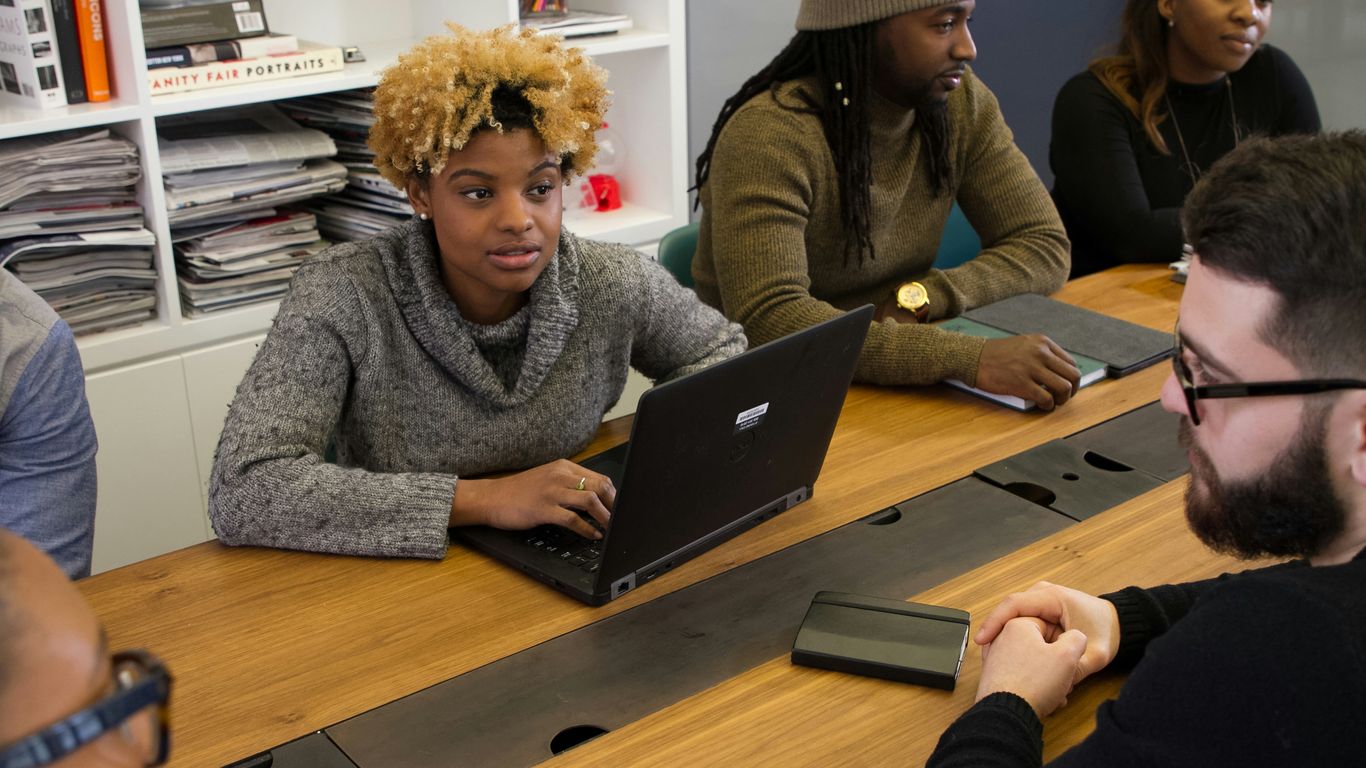 a group of people sitting around a wooden table