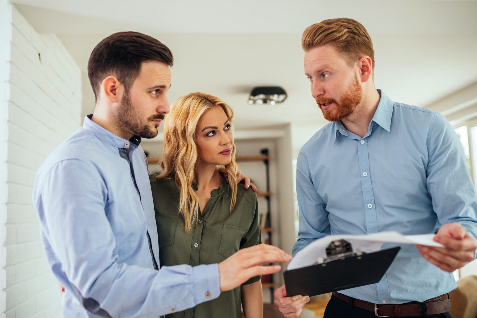 A person shows a document to a couple inside a room