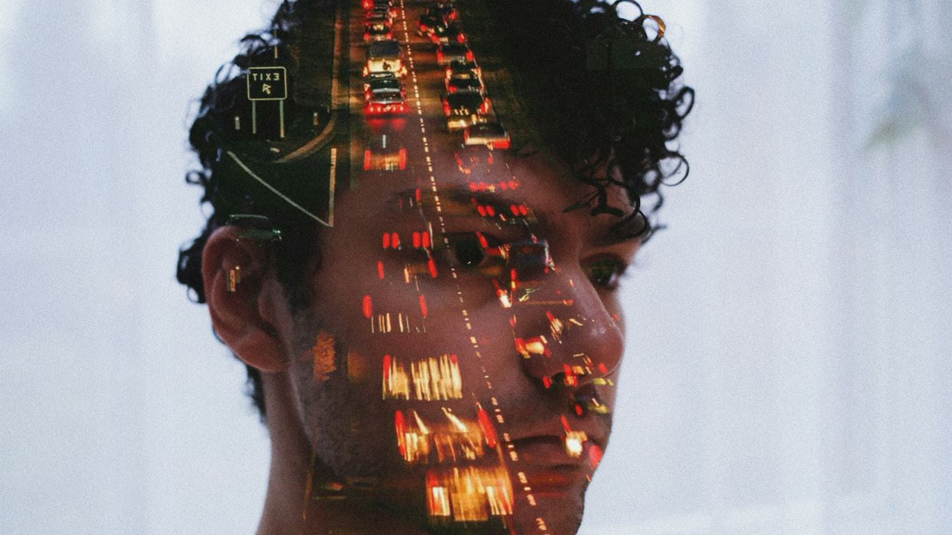 Double exposure of man's face and traffic lights
