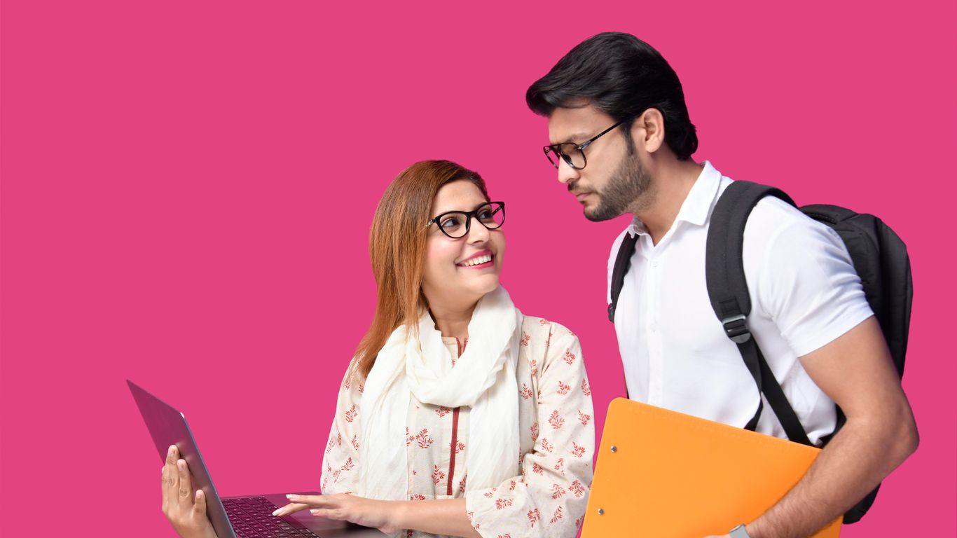 a man and woman looking at a laptop